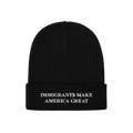 Black knit cuffed beanie hat with “IMMIGRANTS MAKE AMERICA GREAT” embroidered in white on the cuff, representing solidari