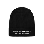 Black knit cuffed beanie hat with “IMMIGRANTS MAKE AMERICA GREAT” embroidered in white on the cuff, representing solidari