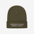 Immigrants Make America Great Hat: Olive-green knit beanie with a folded cuff, featuring white embroidered message advocating for immigrant rights, embodying a stance against hate and supporting equality.