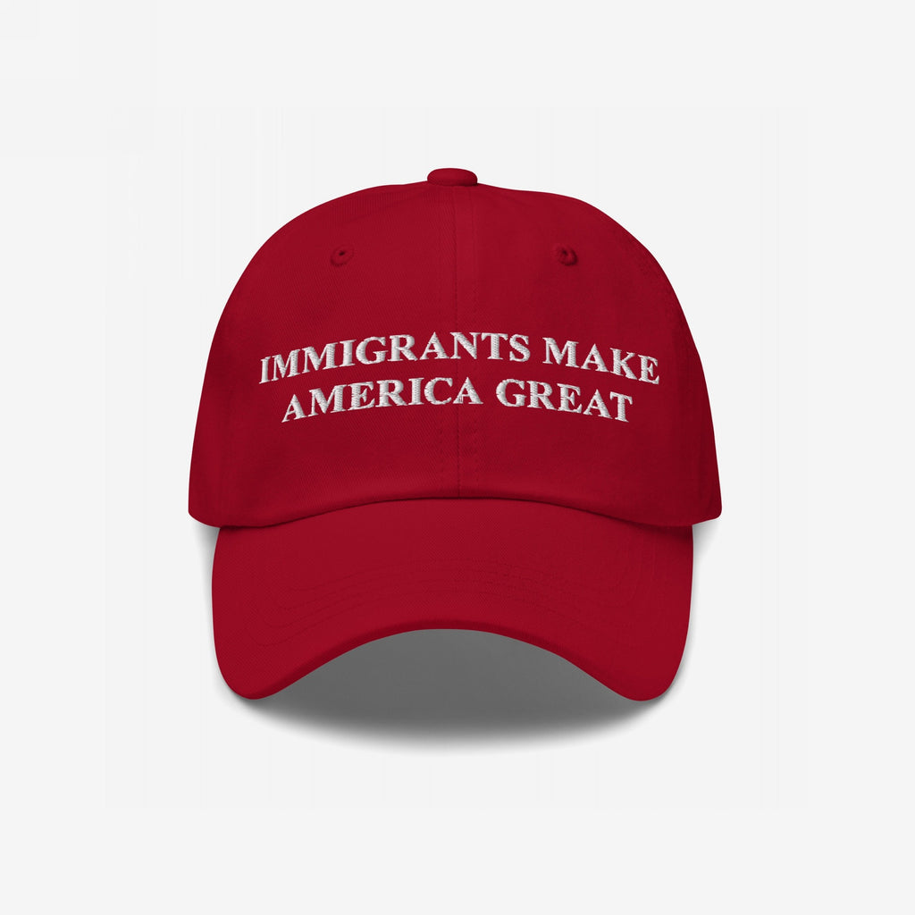 Red baseball-style cap featuring white embroidered text: IMMIGRANTS MAKE AMERICA GREAT. This statement piece supports immigrant communities, aligning with anti-racism and equality values. Benefiting the Immigrant Legal Resource Center (ILRC).
