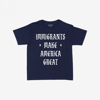 Immigrants Make America Great T-shirt featuring bold white Old English text on a navy-blue background, symbolizing solidarity and resistance against xenophobia and racism. Collar label reads “STRANGE GOODS.”