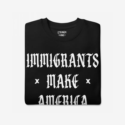 Immigrants Make America Great Sweatshirt featuring bold white Old English lettering on a black fabric, symbolizing immigrant pride and resistance. Small brand logo visible at the neckline.