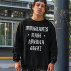 Young man wearing the Immigrants Make America Great Shirt, featuring bold, gothic-style lettering, stands outdoors. Paired with a black baseball cap and camo pants, the look embodies a protest-ready style.