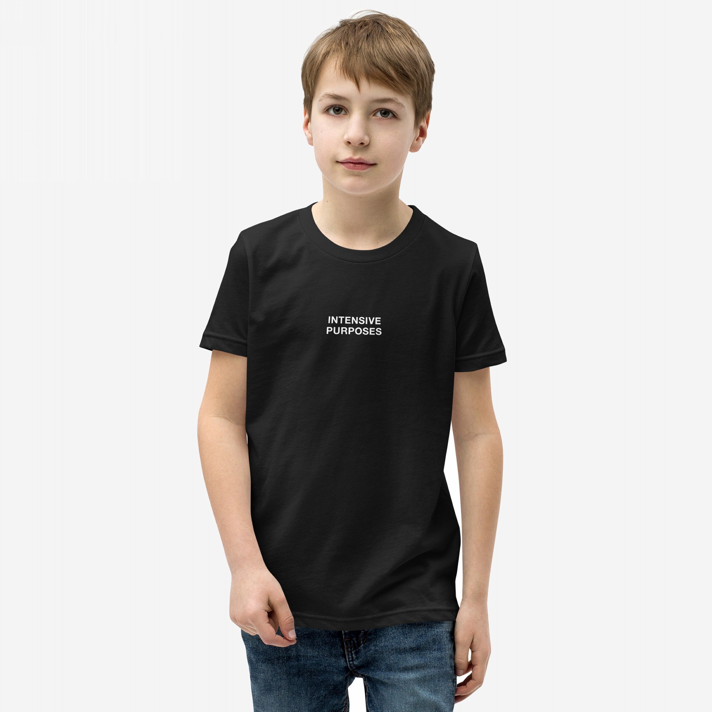 Young boy wearing the Intensive Purposes T-shirt, featuring the phrase INTENSIVE PURPOSES in white text on a black background, styled humorously for grammar enthusiasts and those who embrace linguistic quirks.