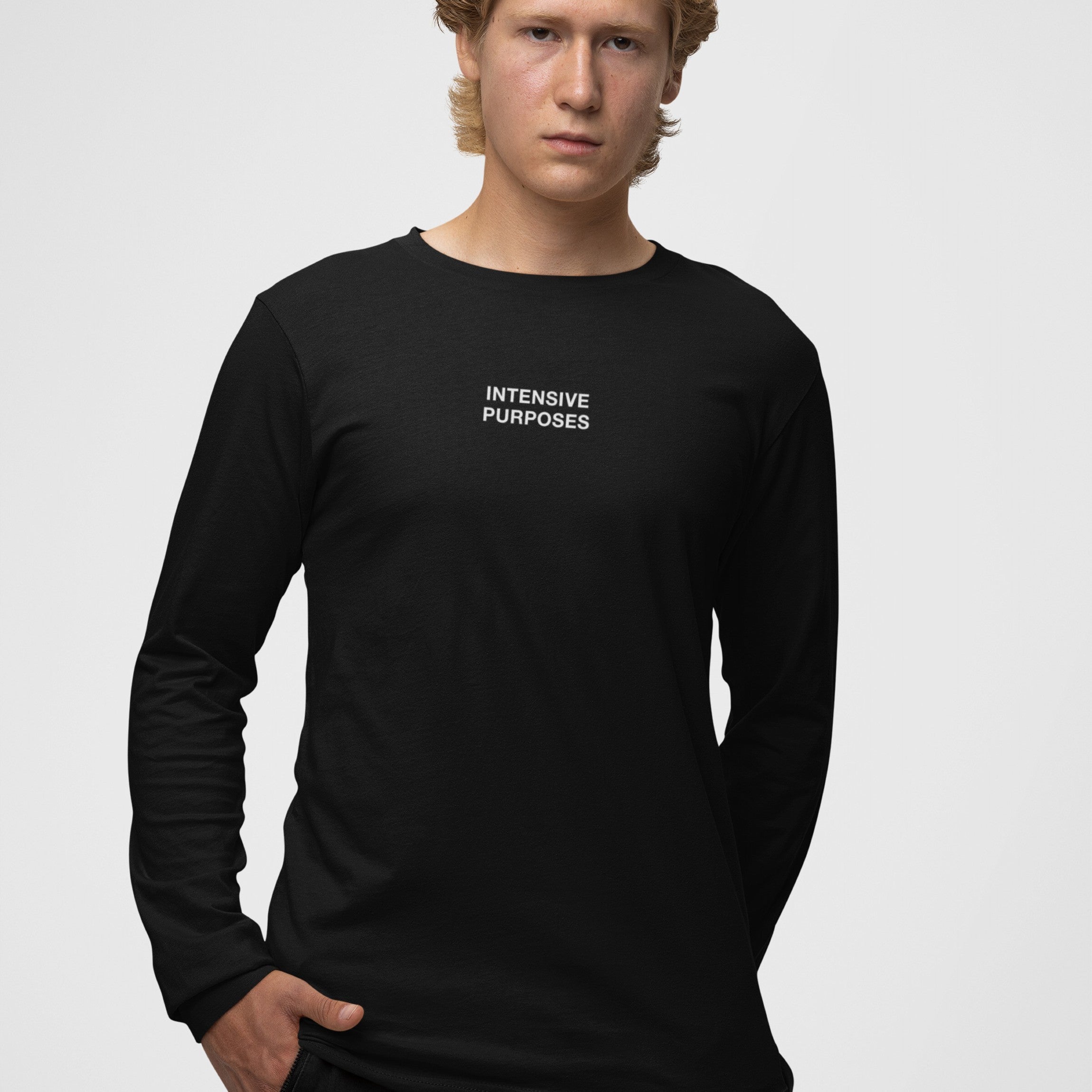 Young man models the Intensive Purposes T-shirt, featuring INTENSIVE PURPOSES text on black long-sleeve, celebrating language mishaps and humor, perfect for the linguistically bold and grammar rebels.