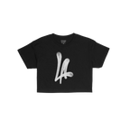 LA Handstyle Women's Baby Tee featuring a bold, white spray-paint “LA” graphic in a dripping tag design on a black short-