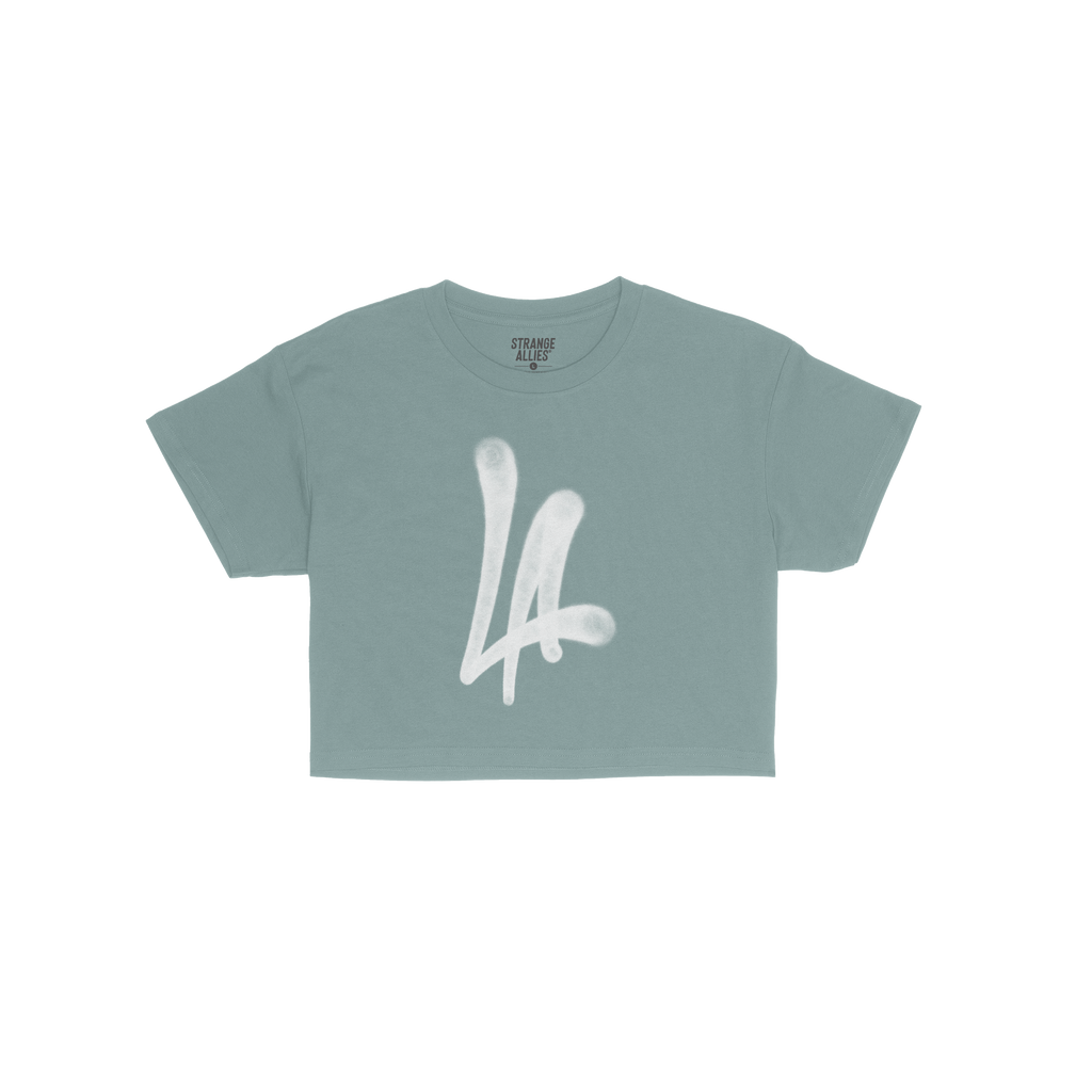 LA Handstyle Women's Baby Tee in medium blue features a bold white LA spray-paint graphic on the chest, capturing a retro Y2K