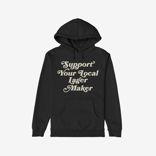 Unisex black pullover hoodie with cream vintage script reading Support Your Local Lager Maker. Features kangaroo pocket, drawstring hood, embodying craft beer pride and local support. Ideal for beer enthusiasts.