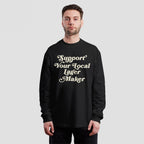 Person wearing a Support Your Local Lager Maker T-shirt, featuring cream-colored vintage lettering, advocating for local breweries. Ideal for expressing support and solidarity with independent lager producers.