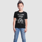 Young girl in black Let It Burn / Melt ICE T-shirt featuring a graphic of a hand holding a flaming Molotov cocktail, advocating against state violence, paired with star-patterned blue jeans.