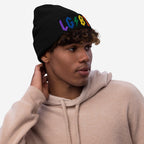 Young person wearing a black beanie with colorful LGBTQ Rocks Hat embroidery, showing pride and rock and roll attitude.