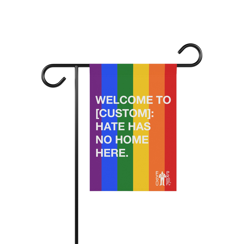 Custom Hate Has No Home Here Pride Garden Flag on a black metal stand, featuring rainbow stripes and white text, promoting in