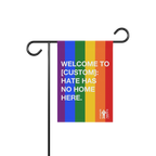 Custom Hate Has No Home Here Pride Garden Flag on a black metal stand, featuring rainbow stripes and white text, promoting in