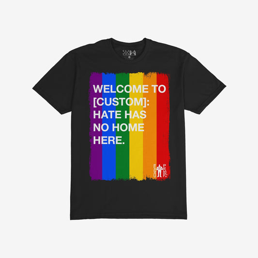 Custom Hate Has No Home Here Pride T-shirt featuring a vertical rainbow-stripe paint stroke graphic with a bold anti-hate message, embodying unity and inclusion.