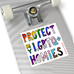 The underside of a skateboard displays the Protect My LGBTQ+ Homies sticker, showcasing vibrant, pride-themed colors and a hand-drawn design, embodying equality and allyship.