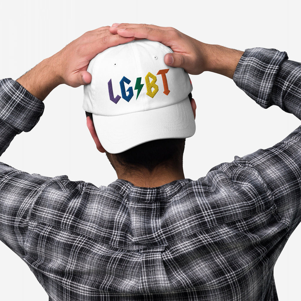 Person wearing a white LGBTQ Rocks Hat with rainbow embroidery and a lightning bolt design on the back, styled with a plaid shirt.