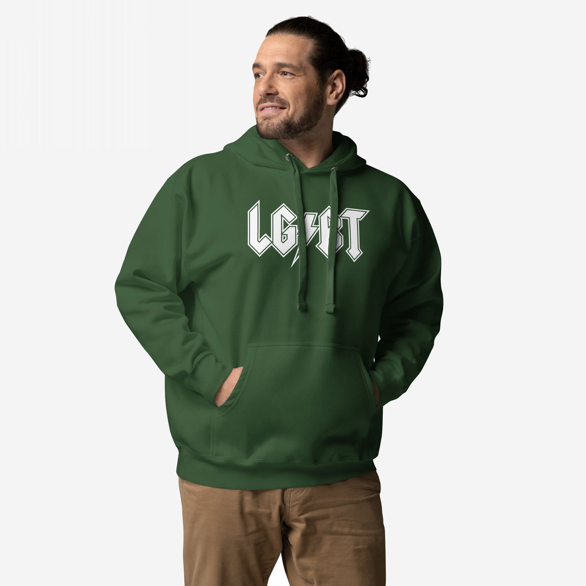 Man in a forest-green LGBTQ Rocks Hoodie with white lettering, showcasing pride and resilience. Hands in kangaroo pocket, paired with light brown pants, capturing bold energy and solidarity.