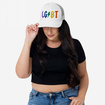 Woman wearing a white LGBTQ Rocks Hat with rainbow embroidery and lightning bolt, styled with a black crop top and blue jeans.