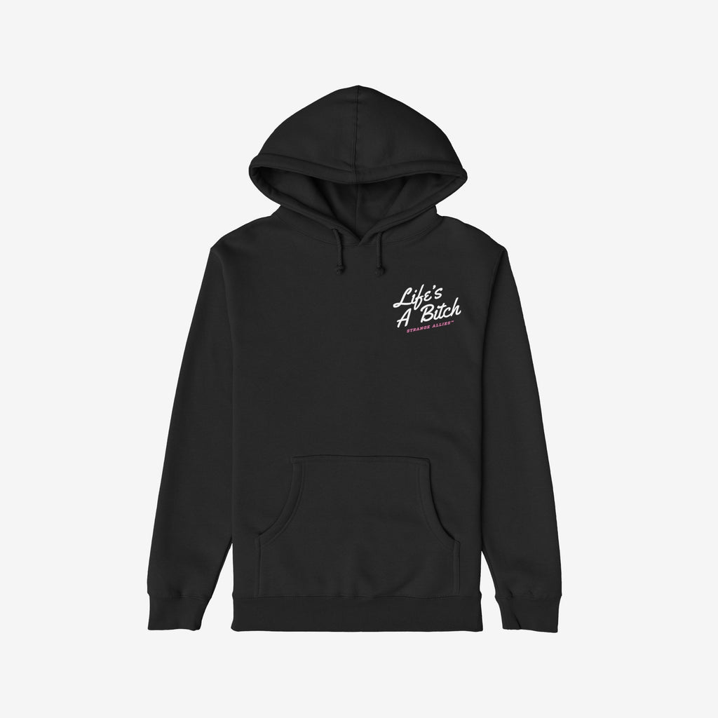 Black pullover hoodie titled Life's A Bitch Shirt featuring white cursive text on left chest. Pink text beneath reads “STRANGE ALLIES™.” A statement piece, combining comfort and cynical truth.