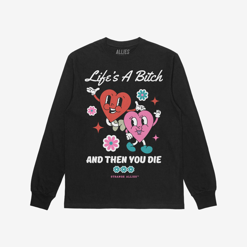 Life's A Bitch Shirt features smiling anthropomorphic hearts with Life's A Bitch above and AND THEN YOU DIE below, capturing a bold, unapologetic message with playful graphics. Brand: STRANGE ALLIES.