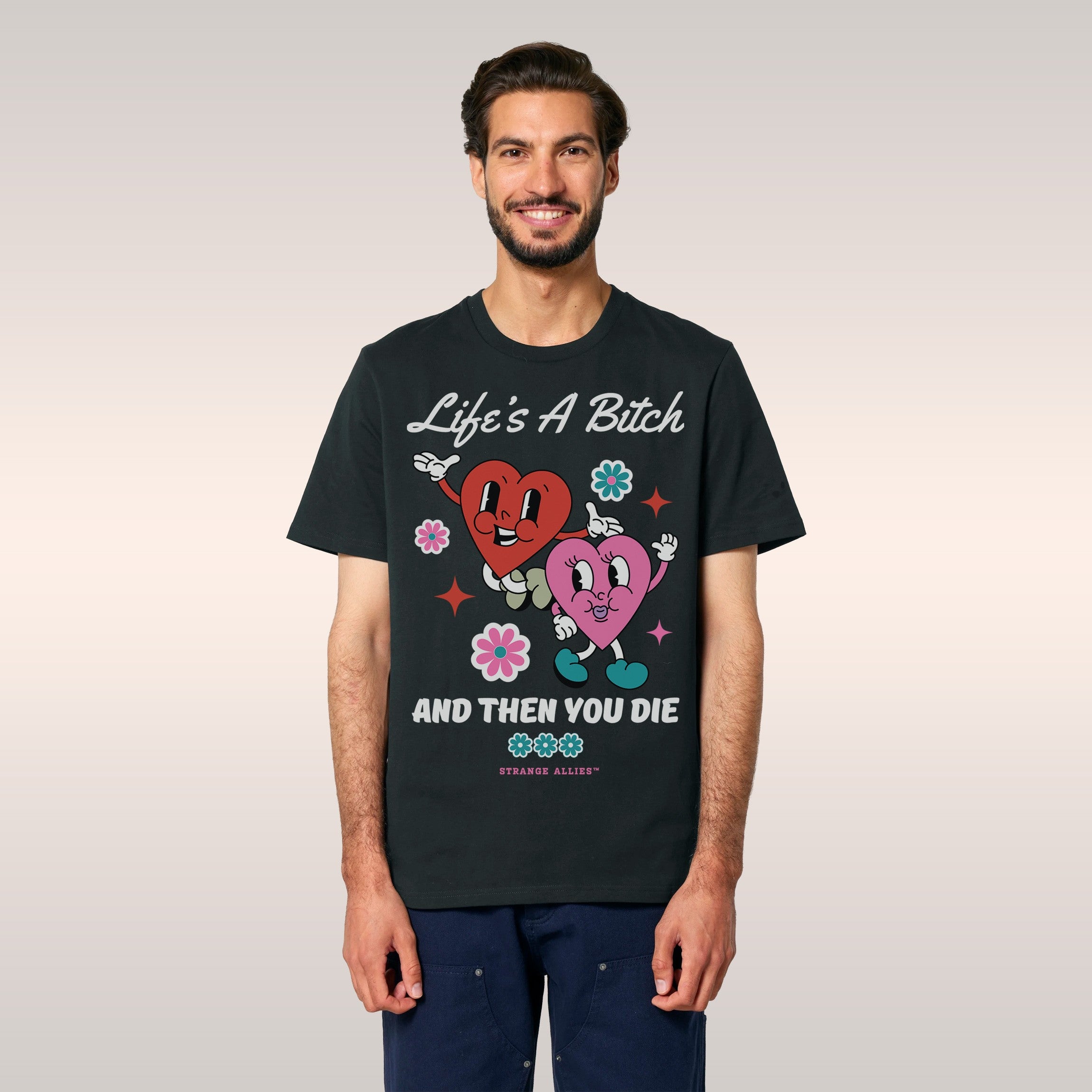 Person wearing a black bucket hat and denim jacket reveals the Life's A Bitch Shirt, featuring cartoon hearts, flowers, and b