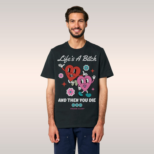 Person wearing a black bucket hat and denim jacket reveals the Life's A Bitch Shirt, featuring cartoon hearts, flowers, and b