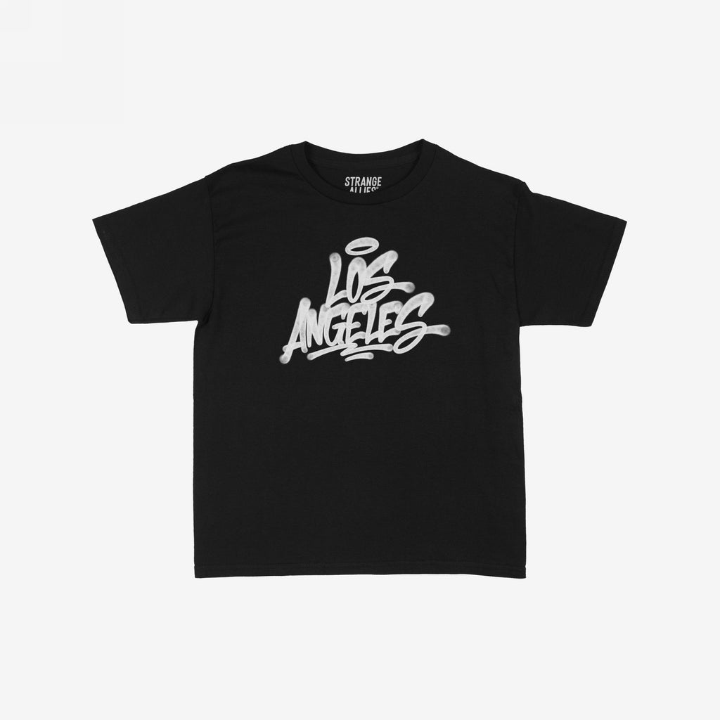 Los Angeles Handstyle Women's Baby Tee, black with white graffiti-style Los Angeles and halo graphic, laid flat. Features STRANGE ALLIES label. Reflects bold, expressive style, supporting equality and diversity.