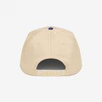 The MAGA Is A Hate Group Hat features a light beige six-panel design with a navy-blue button, adjustable snap-back closure, symbolizing resistance against hate, and advocating for equality.