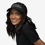 Young woman with braces wears a black MAGA Is A Hate Group Hat, advocating for equality and anti-fascism. The cap features white embroidered text, embodying a bold, progressive statement.