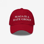 Red baseball-style cap featuring the bold white text MAGA IS A HATE GROUP embroidered on the front, reflecting progressive and anti-fascist values.