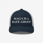 Navy-blue mesh trucker cap with MAGA IS A HATE GROUP embroidered on the front, reflecting anti-fascist and equality themes.