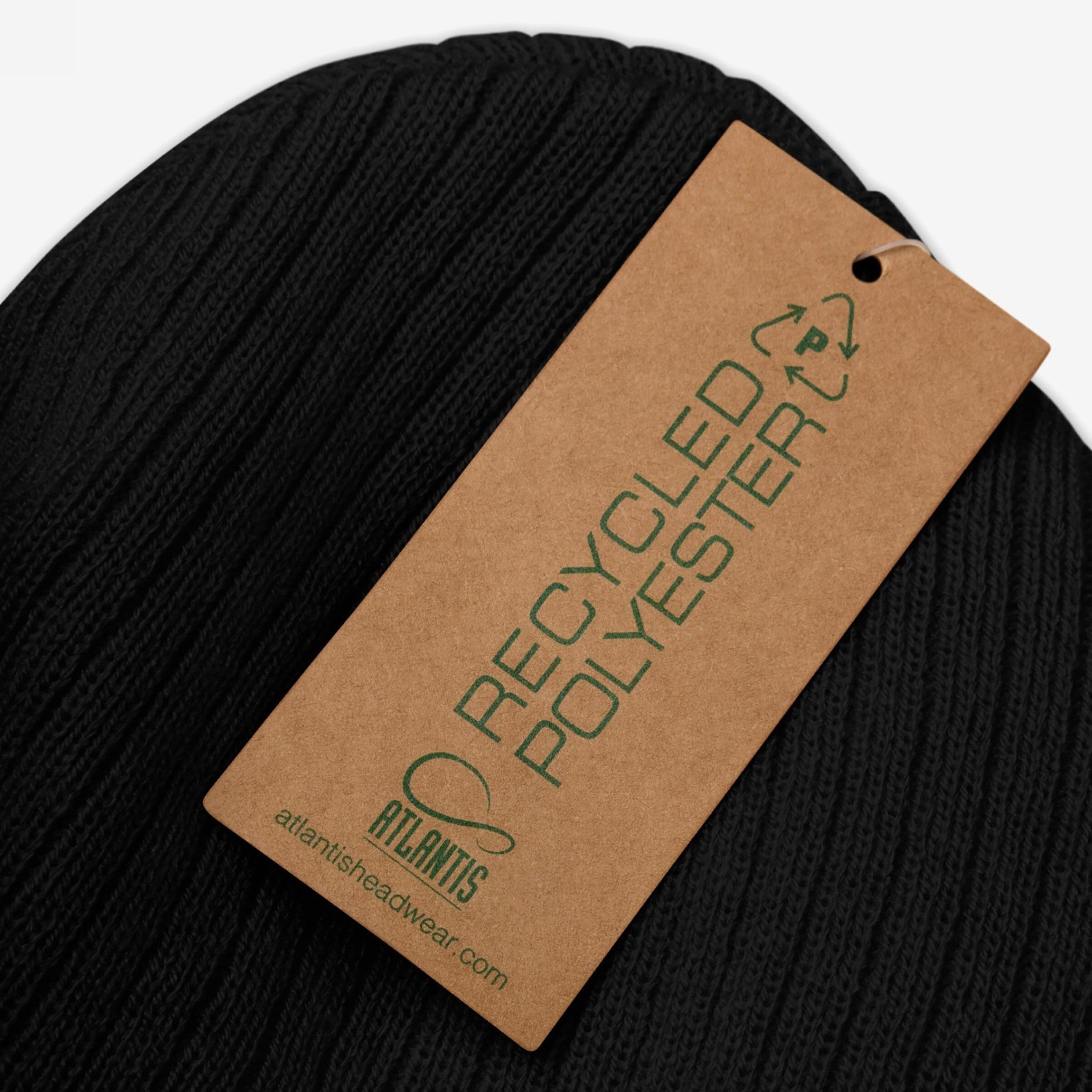 Black rib-knit beanie with “MAKE AMERICA RAGE AGAIN” embroidered in white, featuring a green-tagged RECYCLED POLYESTER label by ATLANTIS. A bold, anti-fascist statement piece for visible activism.