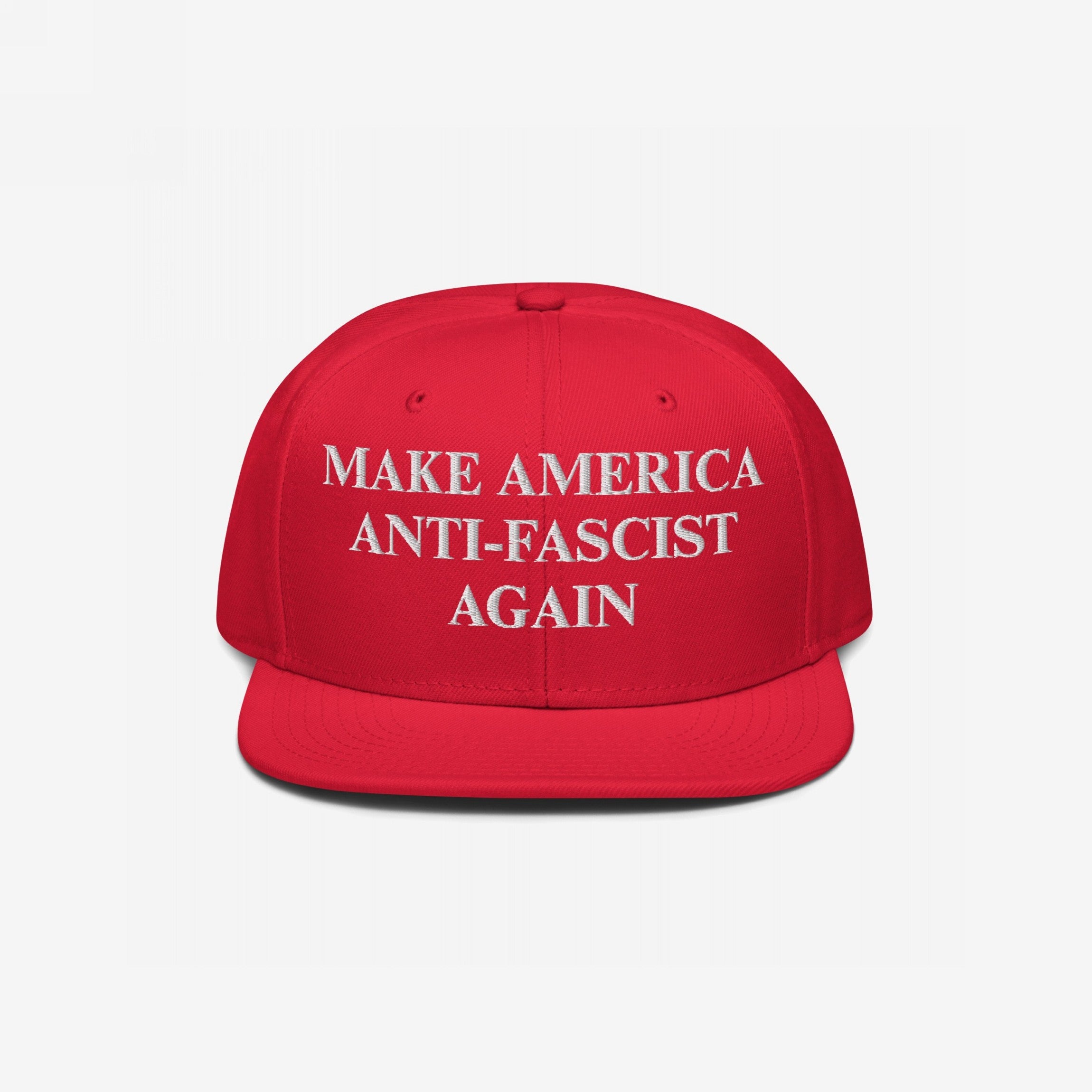 Bright red Make America Anti-Fascist Again Hat features white embroidered text promoting anti-authoritarian values. This snapback cap boldly advocates for democracy and equality, aligning with progressive ideals.