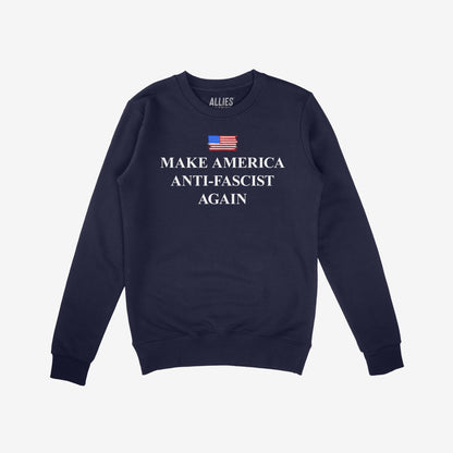 Navy-blue crewneck sweatshirt with Make America Anti-Fascist Again under a small American flag, embodying a bold stance against authoritarianism for those championing democracy and equality.