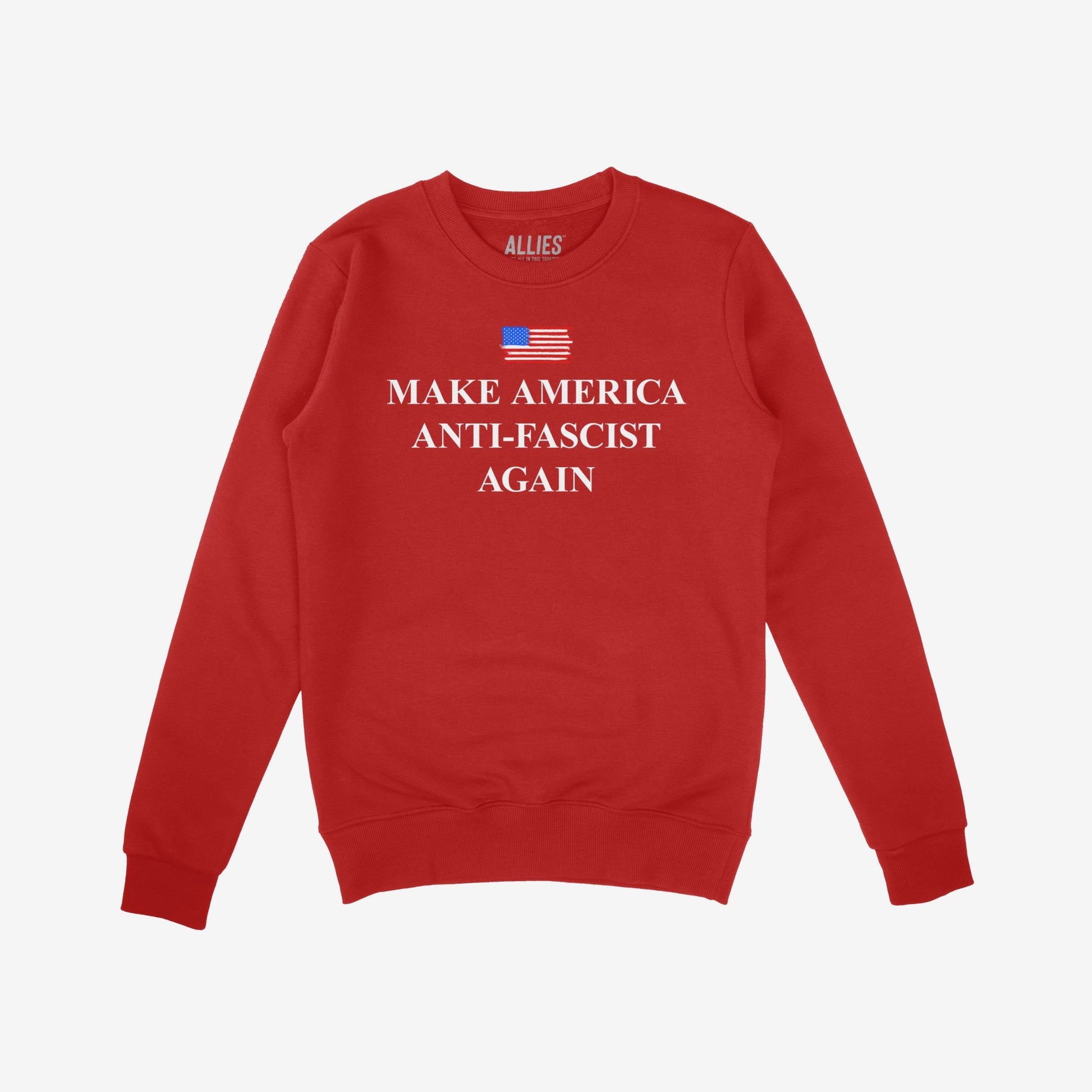 Red crewneck sweatshirt featuring the Make America Anti-Fascist Again slogan and a stylized U.S. flag, embodying a stand against authoritarianism and promoting equality. Brand ALLIES inside collar.