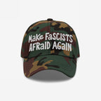Camo-patterned Make Fascists Afraid Again hat with white, hand-drawn embroidery. Designed for bold resistance and activism, supporting equality and justice. Perfect for protests or casual wear. Proceeds benefit ACLU.
