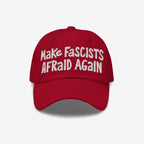 Make Fascists Afraid Again Hat featuring bold white embroidery on a red baseball cap, embodying anti-fascist sentiment with a casual, defiant style.