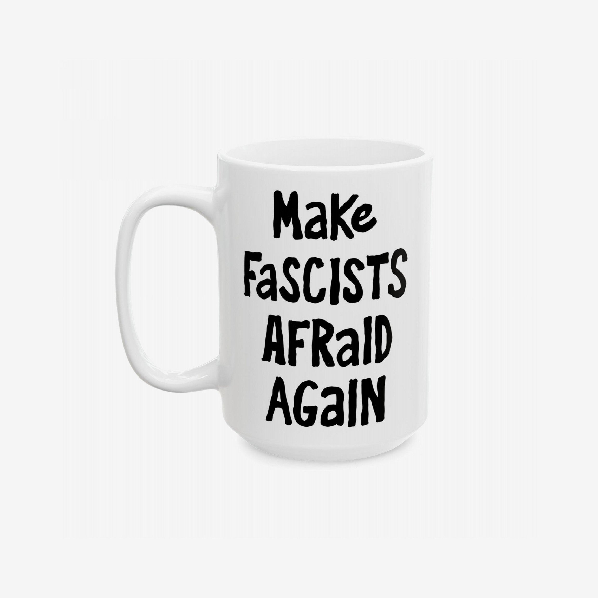 White ceramic mug with black, hand-drawn lettering: “Make Fascists Afraid Again”. Bold message supports resistance, ideal for activism-minded coffee lovers. Available in 11 oz and 15 oz sizes.