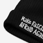 Black knitted Make Fascists Afraid Again hat with white, hand-drawn embroidery, embodying everyday resistance and bold style. Supports ACLU, perfect for protests or casual wear with an activist edge.