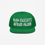 Green, flat-brimmed Make Fascists Afraid Again hat with white, hand-drawn embroidery, symbolizing resistance and activism. Perfect for those standing against fascism and supporting equality.