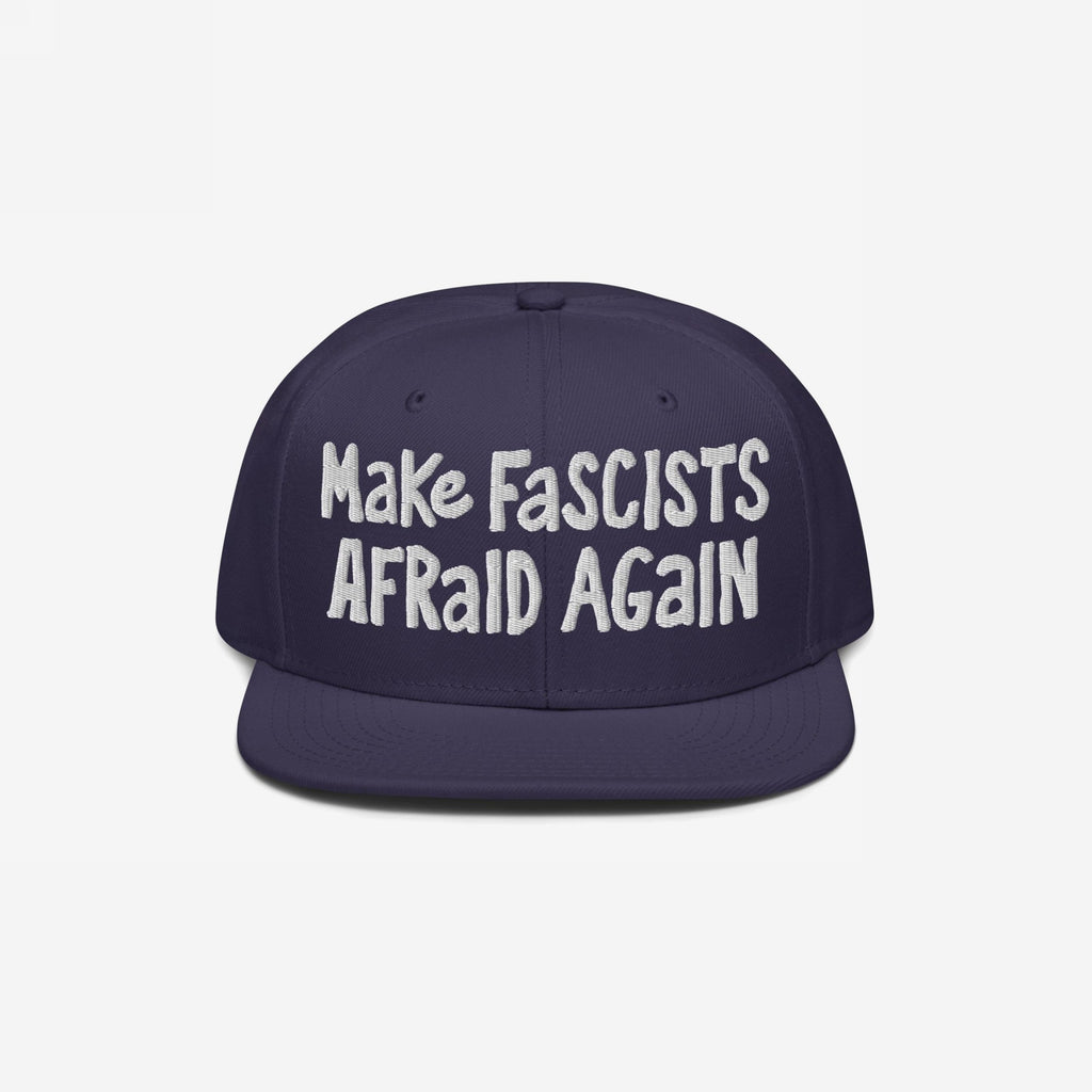 Dark-blue flat-brim cap with white embroidery reading “Make Fascists Afraid Again.” Features raw, hand-drawn style for everyday resistance; proceeds support the ACLU.