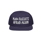 Dark-blue flat-brim cap with white embroidery reading “Make Fascists Afraid Again.” Features raw, hand-drawn style for ev