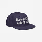 Make Fascists Afraid Again Hat features a navy-blue flat-brim design with raw, hand-drawn white embroidery. It's a bold statement piece for everyday resistance, benefiting the ACLU.