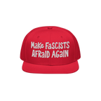 Red flat-brim cap with “Make Fascists Afraid Again” in white embroidery; embodies a bold, rebellious statement against fa