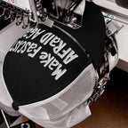 Black-and-white mesh-back trucker cap in embroidery machine, stitching Make Fascists Afraid Again slogan. Features bold, hand-drawn embroidery, embodying protest spirit and challenging norms. Supports ACLU initiatives.