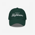 Dark-green Mayor Of Hightown Hat with white embroidered text, embodying a playful, rebellious spirit for cannabis enthusiasts and festival-goers, capturing the essence of elevated humor and carefree energy.