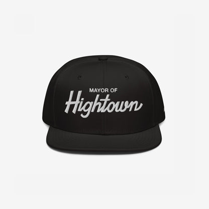 Black snapback hat featuring Mayor of Hightown in white embroidery, embodying a playful and bold statement for cannabis culture enthusiasts, reflecting an inclusive and high-spirited ethos.