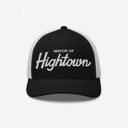 Trucker-style baseball cap with white mesh back, featuring MAYOR OF Hightown embroidered on the black front, reflecting a playful, high-spirited vibe for cannabis enthusiasts and humor lovers.