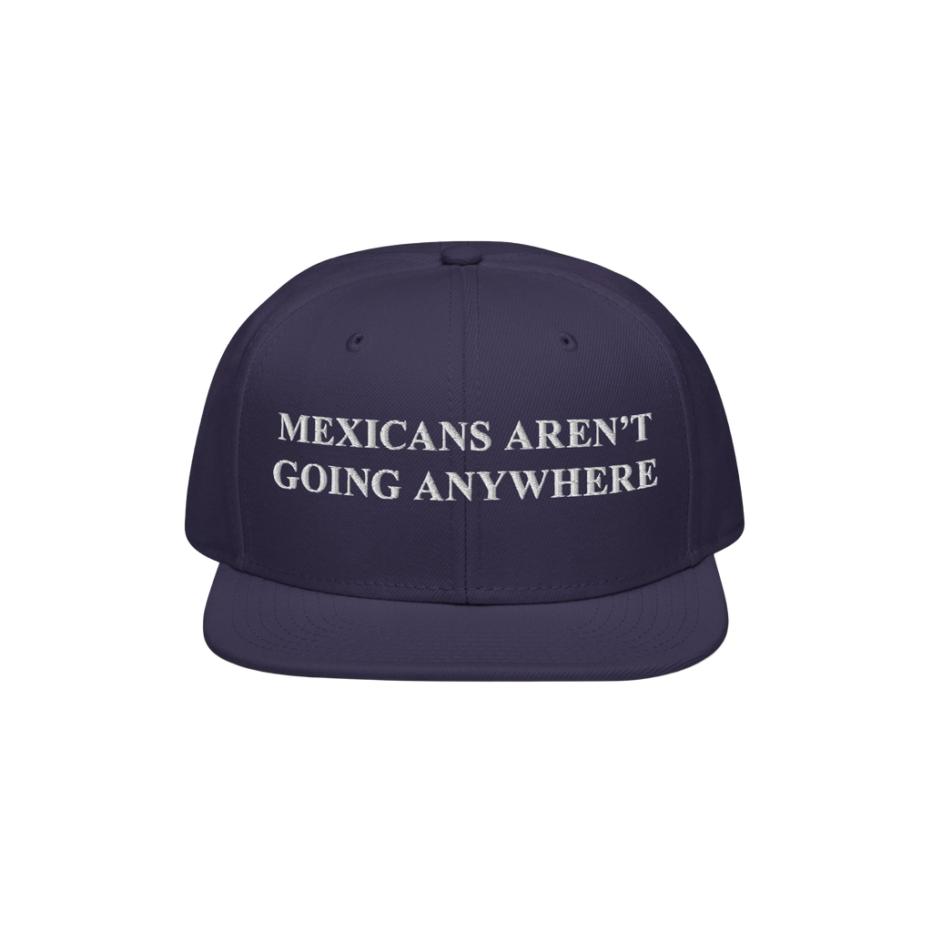 Navy snap-back cap with white embroidered Mexicans Aren’t Going Anywhere text, embodying pride and resistance against racis