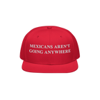 Red snap-back baseball cap with white embroidered text, “Mexicans Aren’t Going Anywhere,” symbolizing pride and resista